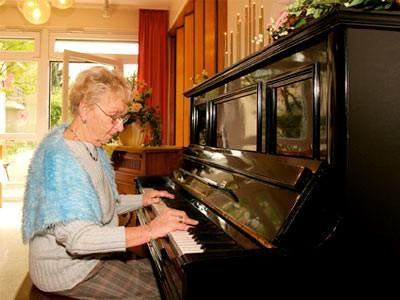 Bewohnerin beim Klavierspielen im Senioren- und Pflegezentrum